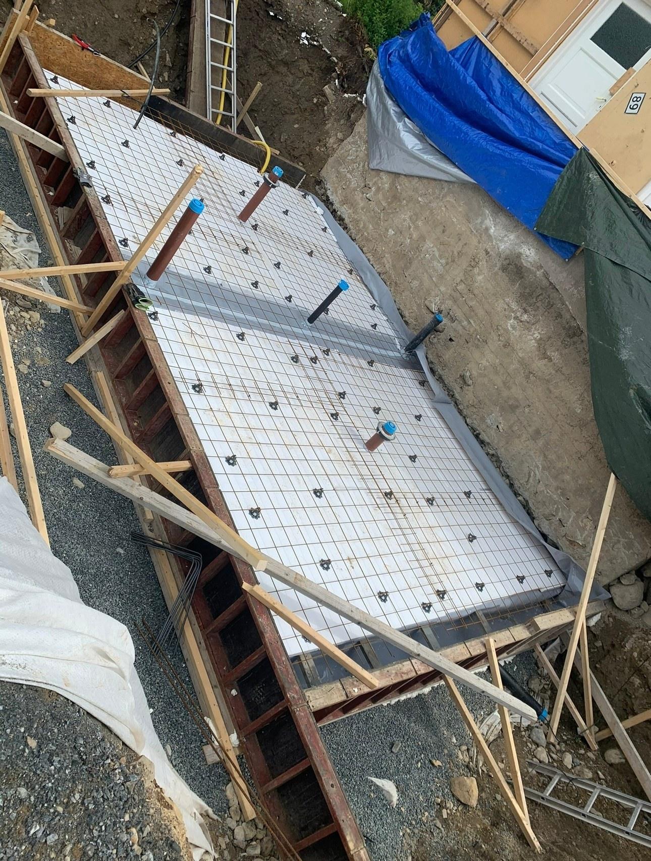 Formwork for a slab on grade, with insulation and reinforcement laid ready for concrete